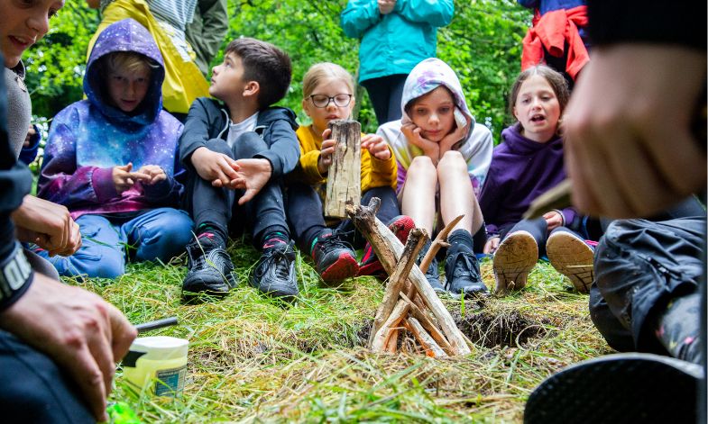 Primary children sat around the camp fire