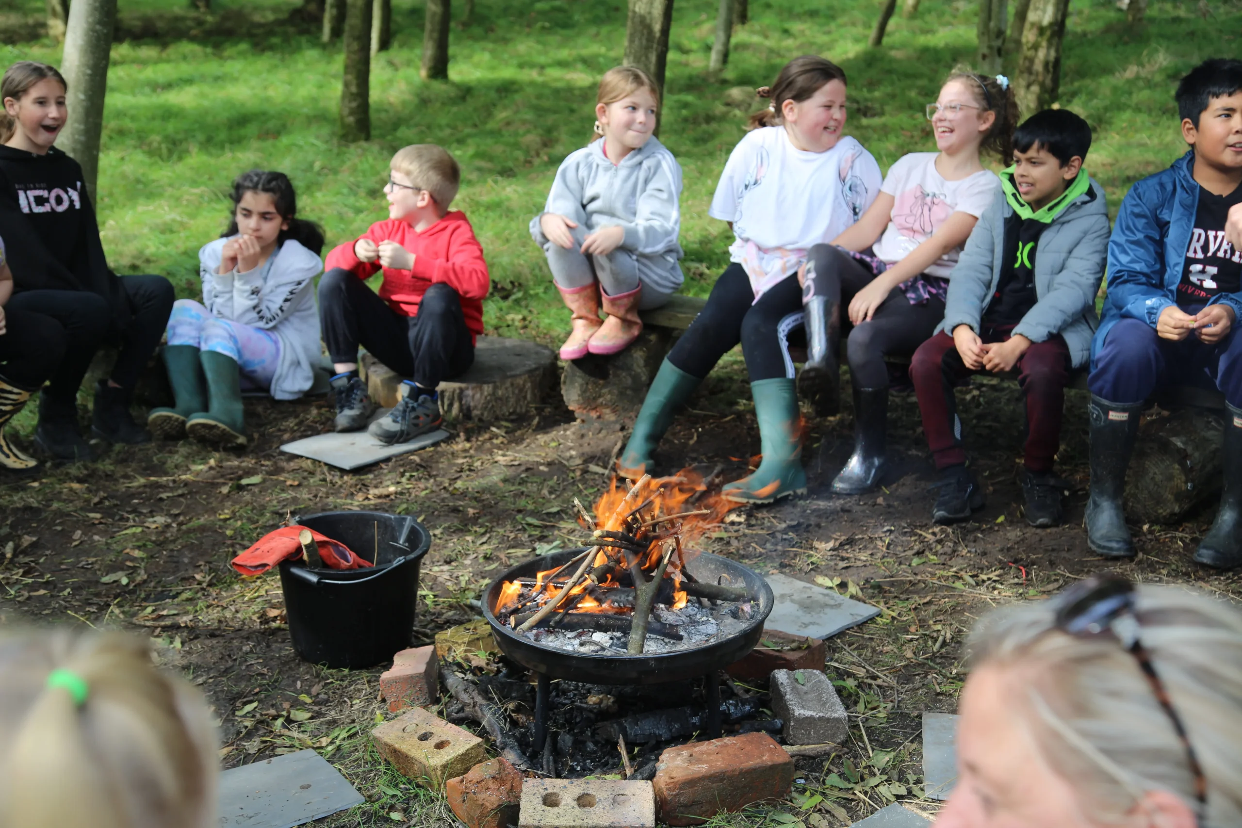 Primary school children around a fire pit